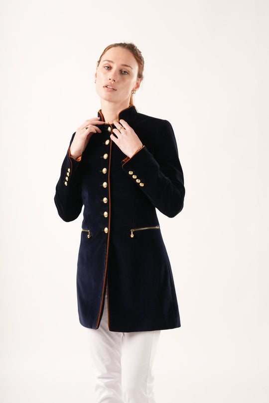 Our Seville Navy Velvet Coat is a tailored dream. The tan piping detailing and muted gold buttons contrast beautifully with the navy velvet, and the inside cuffs reveal exquisite pops of colour. The zipped pockets with crown charms are playful and the mid length style is refined. We think this coat pairs beautifully with the Phoebe Gold Shirt and Brooklyn Navy Boots.